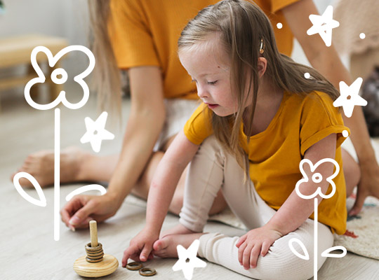 A young girl with SEND enjoys playing blocks with an adult.