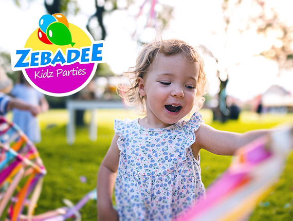 Little girl laughing and playing with pretty coloured ribbons